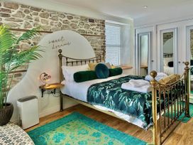 A bedroom with a bed, bedside table, and a plant at an unknown property in an unknown location