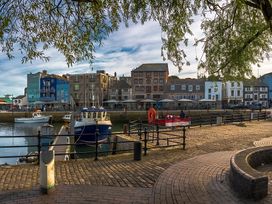 A waterfront scene with boats and buildings near the dock at Seafront Cottage in 