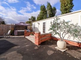 An outdoor area with a hot tub and seating at Lodge in Talacre