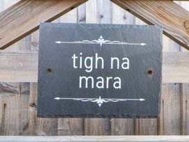 A slate sign reading tigh na mara on a wooden fence at Lodge Talacre