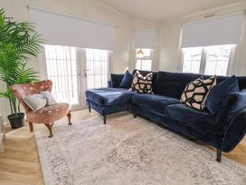 A living room with a sofa and a chair at Lodge in Talacre
