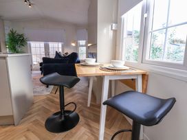 A kitchen with bar stools and a dining table at Lodge in Talacre