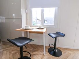 A kitchen with a table and stools at Lodge in Talacre