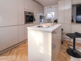 A kitchen with a sink and bar stool at Lodge in Talacre
