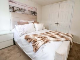 A bedroom with a bed and pillows at the Lodge in Talacre