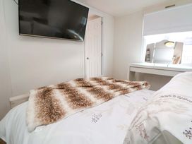 A bedroom with a TV and a bed at Lodge in Talacre