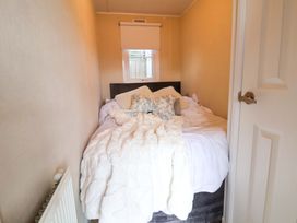 A bedroom with a bed and window at Lodge in Talacre