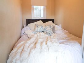 A bedroom with a bed and pillows at Lodge in Talacre