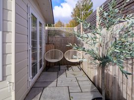 An outdoor patio with two chairs and a tree at Lodge in Talacre