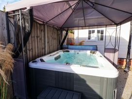 A hot tub under a canopy in an outdoor area at Lodge Talacre