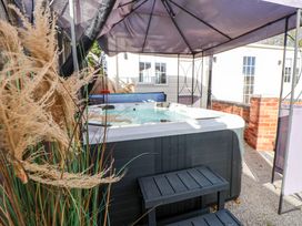 A hot tub under an umbrella at Lodge in Talacre