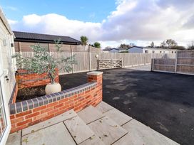 An outdoor area with a brick wall and a planter at Lodge in Talacre