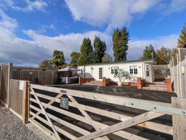 An outdoor area with a house and patio furniture at Lodge in Talacre