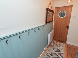 A hallway with hooks and a mirror at Corner Cottage in Seahouses