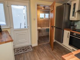 A kitchen with a door and access to bathroom at Corner Cottage in Seahouses