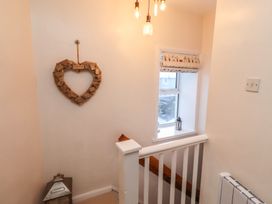 A hallway with a staircase and a decorative heart at Corner Cottage in Seahouses