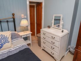 A bedroom with a bed and dresser at Corner Cottage in Seahouses
