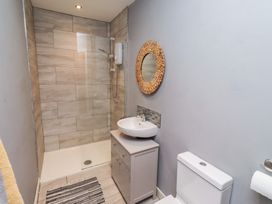 A bathroom with a shower, sink, and toilet at Corner Cottage in Seahouses