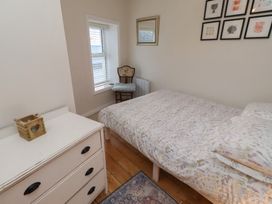 A bedroom with a bed and chair at Corner Cottage Seahouses