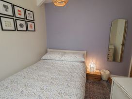 A bedroom with a bed and wall art at Corner Cottage in Seahouses
