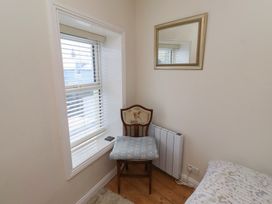 A chair near a window and mirror at Corner Cottage in Seahouses