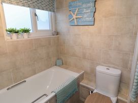 A bathroom with bathtub and toilet at Corner Cottage in Seahouses