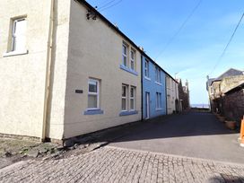 A street view showing buildings and flower pots at Corner Cottage in Seahouses