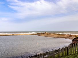 A coastal view with water and rocks at Corner Cottage in Seahouses