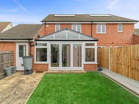A conservatory with glass doors and a garden at the property