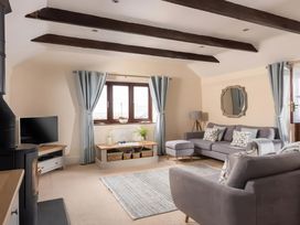 A living room with a tv, sofa, and curtains at The Granary near St Merryn