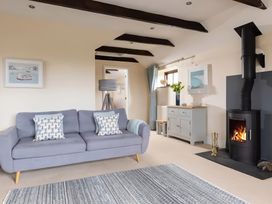 A living room with a sofa and fireplace at The Granary, Engollan near St Merryn