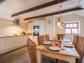 A kitchen with a dining area and wooden table at The Granary, Engollan near St Merryn