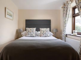 A bedroom with a bed and decorative pillows at The Granary, Engollan near St Merryn