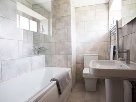 A bathroom with a bathtub, sink, and toilet at The Granary, Engollan near St Merryn