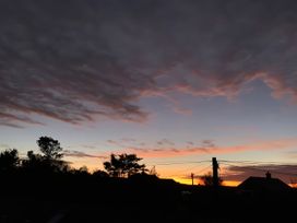 A sunset view with trees and houses at The Granary, Engollan near St Merryn