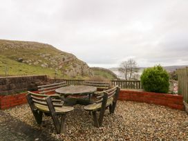 A patio area with a table and chairs at 3 Bay View Terrace in Llandegfan