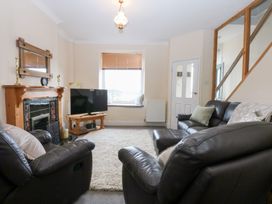 A living room with a television and sofa at 3 Bay View Terrace in Llandegfan