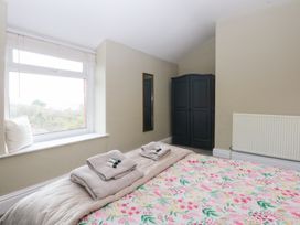 A bedroom with a bed and wardrobe at 3 Bay View Terrace in Llandegfan
