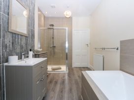 A bathroom with a bath tub and a shower at 3 Bay View Terrace in Llandegfan