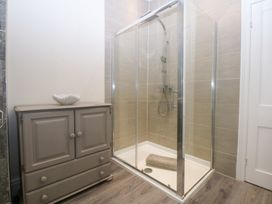 A bathroom with a shower and cabinet at 3 Bay View Terrace in Llandegfan