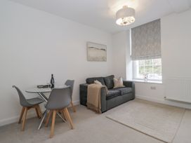 A living room with a dining table and sofa at Derwent in Ulverston