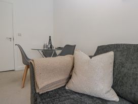 A living room with a sofa and dining area at Derwent in Ulverston