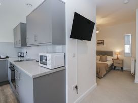 A kitchen with appliances and a view of the bedroom at Derwent in Ulverston