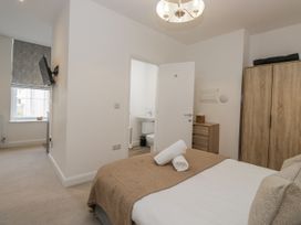 A bedroom with a bed and a bathroom door at Derwent in Ulverston