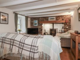 A living room with a sofa and television at Blowing House Cottage in Perranporth