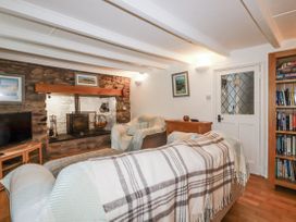 A living room with a sofa and television at Blowing House Cottage in Perranporth