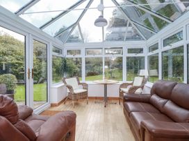 A conservatory with seating and a table at Blowing House Cottage Perranporth