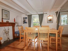 A dining room with a wooden table and chairs at Blowing House Cottage Perranporth