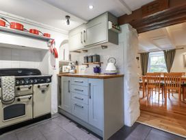 A kitchen with a stove and cabinets at Blowing House Cottage in Perranporth
