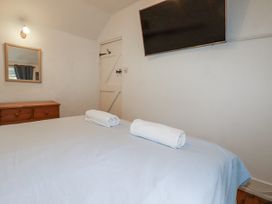 A bedroom with a bed and towels at Blowing House Cottage Perranporth
